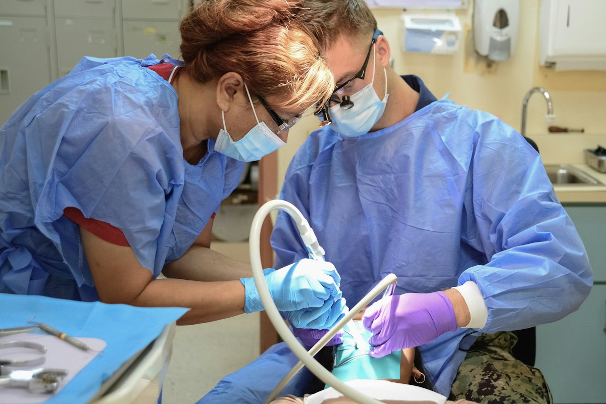 Dentists treating a patient in a bright treatment room